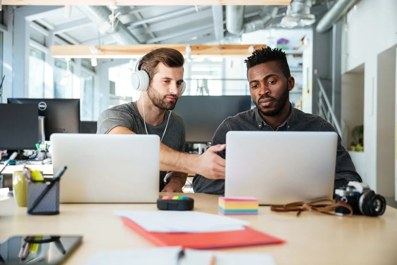 Junge ernste Kollegen sitzen in einem Coworking-Space.